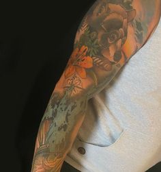 a man with tattoos on his arm holding a cell phone