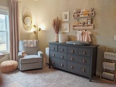 a baby's room with a dresser and chair