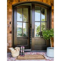 the front door to a home with two plants