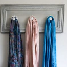 three scarves are hanging on the wall