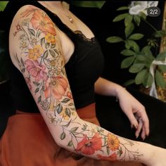 a woman with flowers on her arm is sitting down