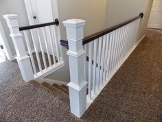 the stairs are white with black railings on each handrail and carpeted floor