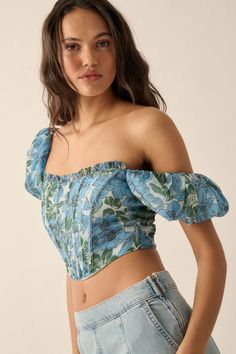 Floral-print chiffon corset top. Square neckline with ruffle. Short puff sleeves. Corset-style bodice with flexible boning. Low, scoop back. Zipper back closure. Cropped length. Sleeveless lining. Fitted silhouette. 100% Polyester. Imported. Designed in LA. Model wears size S. Spring Off-shoulder Fitted Corset, Blue Fitted Puff Sleeve Top, Fitted Blue Puff Sleeve Top With Short Sleeves, Fitted Blue Puff Sleeve Top For Spring, Off-shoulder Fitted Blouse With Smocked Bodice, Blue Cropped Corset For Spring, Fitted Off-shoulder Blouse With Smocked Bodice, Blue Cropped Corset For Summer, Spring Blue Corset