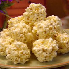 some popcorn on a plate with purple flowers in the background