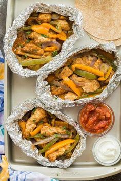 chicken fajita wraps on a tray with salsa and pita bread