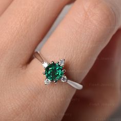 ◆The ring draws inspiration from the polaris. Hand-finished in Sterling sliver, this piece features a round shaped emerald. Clear zirzons decorate around the main stone. An extremely simple celestial ring that you cannot miss. ◆ Production Description: Main stone Type: Emerald Main Stone Shape: Round Main Stone Size: 6*6mm Side stone: CZ Metal: 925 Sterling silver - Other options available in the drop down menu ◆ Customization: √Free for Add Engraving √Other Metal Type Available √Other Gemstones Emerald Crystal Ring Fine Jewelry, Sterling Silver Emerald Ring With Brilliant Cut, Sterling Silver Round Emerald Ring With Brilliant Cut, Round Sterling Silver Emerald Ring With Brilliant Cut, Emerald Crystal Ring With Center Stone, Round Brilliant Cut Emerald Ring In Sterling Silver, Emerald Crystal Ring With Prong Setting In Round Cut, Emerald Crystal Ring With Birthstone Round Shape, Emerald Crystal Ring With Birthstone