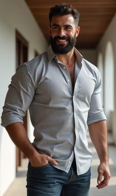 a man with a beard is posing for the camera while wearing jeans and a shirt