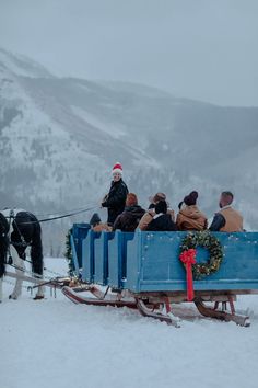 people are riding in a sleigh pulled by horses