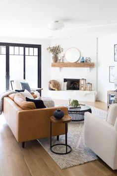 a living room with white walls and brown furniture in the center, on instagram