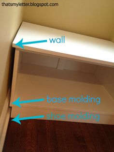 a white shelf with blue arrows pointing to the wall and base molding on it