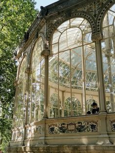 the inside of a glass and stone building with trees in the background