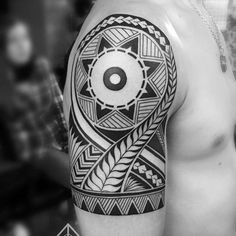 a black and white photo of a man's arm with an abstract tattoo design on it