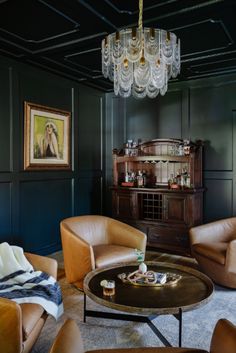 a living room filled with lots of furniture and a chandelier hanging from the ceiling