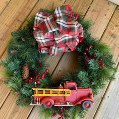 a christmas wreath with a red truck and pine cones