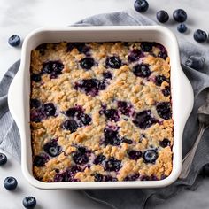 a casserole dish with blueberries and oatmeal crumbles