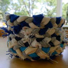 a blue and white basket sitting on top of a wooden table