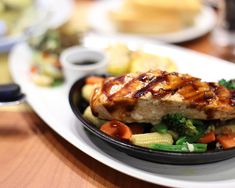 a close up of a plate of food with meat and veggies on it