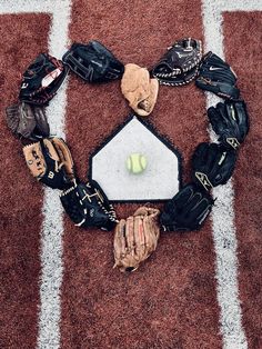 a baseball glove, mitt, and ball laying on the ground next to each other