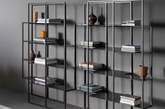 a book shelf with many books on it in a room next to a rug and wall