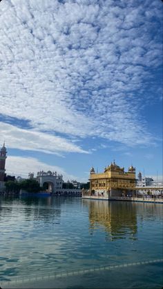 the golden building is surrounded by water and clouds