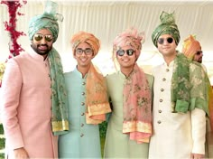 three men in turbans standing next to each other with one man wearing sunglasses