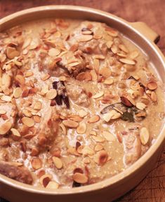 a pan filled with oatmeal and nuts on top of a wooden table