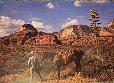 a man standing next to a horse in the desert