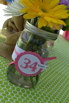 there is a jar with flowers in it and a sign that says 34 years on it