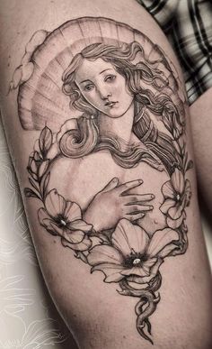 a woman's thigh with flowers and an image of the virgin mary on it