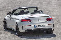 the rear end of a silver mercedes sls roadster convertible parked in a parking lot