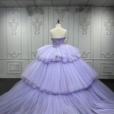 Transform your quinceanera into a fairytale with this enchanting Strapless Crystal Lavender Ball Gown. This dress is crafted with layers of delicate tulle that capture elegance and sophistication, perfect for celebrating your milestone moment. The strapless neckline accentuates your natural beauty, while the intricate appliques add a luxurious touch of artistry. A lace-up back ensures a tailored fit, combining comfort with regal style. The voluminous ball gown silhouette cascades into a dreamy s Purple Prom Dresses, Tiered Gown, Crystal Purple, Purple Prom, Dress Ball Gown, Purple Prom Dress, Clive Christian, Tulle Sleeves, Quinceanera Dress