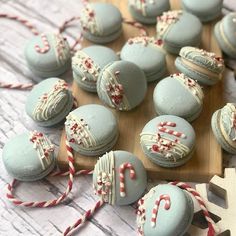 several macaroons on a wooden board with candy canes