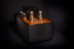 an amplifier with some lights on it's side and two tubes attached to the front