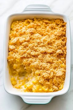 macaroni and cheese casserole in a white dish on a marble surface