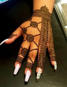 a woman's hand is decorated with hennap and white nail polishes