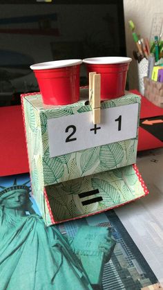 two red cups sitting on top of a desk