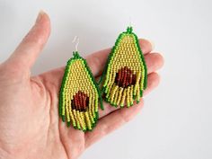 a pair of earrings made out of seed beads with an avocado design on them