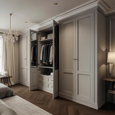 an open closet with clothes hanging on the doors and two lamps in front of it