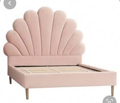 a pink bed with an intricate shell shaped headboard and foot board on the bottom