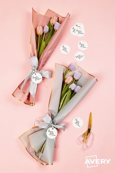 two bouquets of tulips wrapped in paper and tied with ribbon on pink background