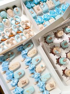 two boxes filled with blue and white cupcakes on top of a table next to each other