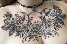 a woman's chest with flowers and crescent moon tattoos on her left side breast