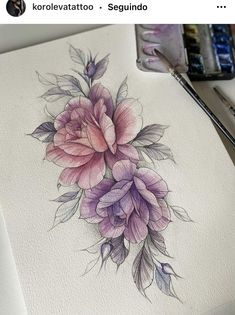 a drawing of flowers on paper with watercolor pencils and paintbrushes next to it