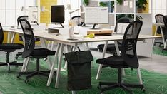 an office with green carpeting and black chairs