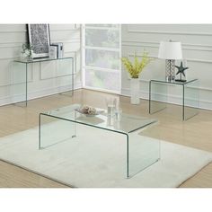 three glass tables sitting on top of a rug in front of a white wall and floor