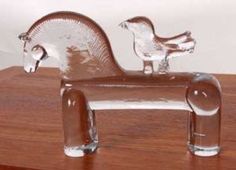 a glass horse and foal sitting on top of a wooden table