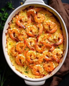 a casserole dish with shrimp and grits in it on a brown cloth