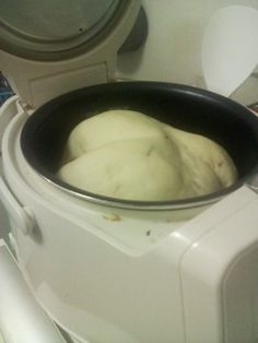 a bowl filled with dough sitting on top of a counter