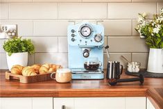 a blue coffee machine sitting on top of a counter next to some croissants