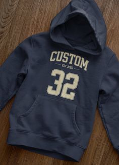 Introducing our Custom Sports Hoodie, a perfect blend of style and personalization that allows you to showcase your passion for sports in a unique way. Whether you're a dedicated athlete or a die-hard fan, this hoodie is designed to be a true representation of your love for the game. Crafted with premium materials, our hoodie offers exceptional comfort and durability, making it ideal for both everyday wear and intense athletic activities. The custom number feature adds a special touch, enabling Sport Inspiration, Varsity Style, Unique Hoodies, Yoga Tank Tops, Sports Hoodies, Etsy Personalized Gifts, Die Hard, Style Shirt, Yoga Women